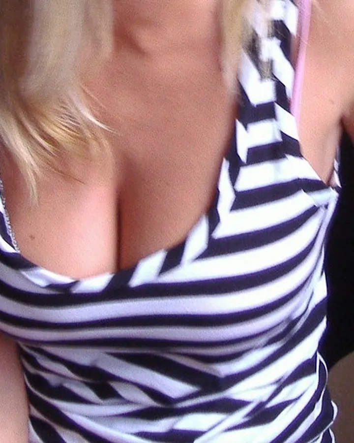 Femme en tenue rayée noire et blanche, prise en photo de face, mains sur les hanches, regardant l'appareil.