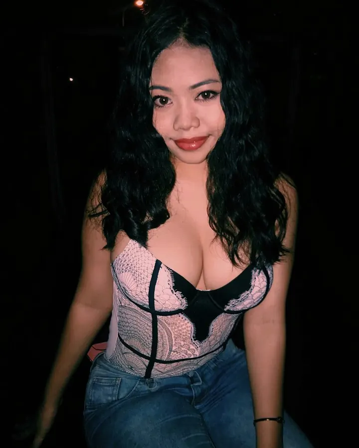 Jeune femme asiatique en haut noir, posant dans une cuisine moderne