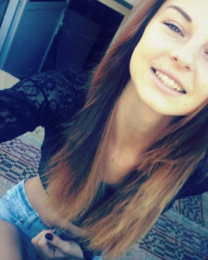 Jeune femme blonde en haut noir, posant avec un sourire